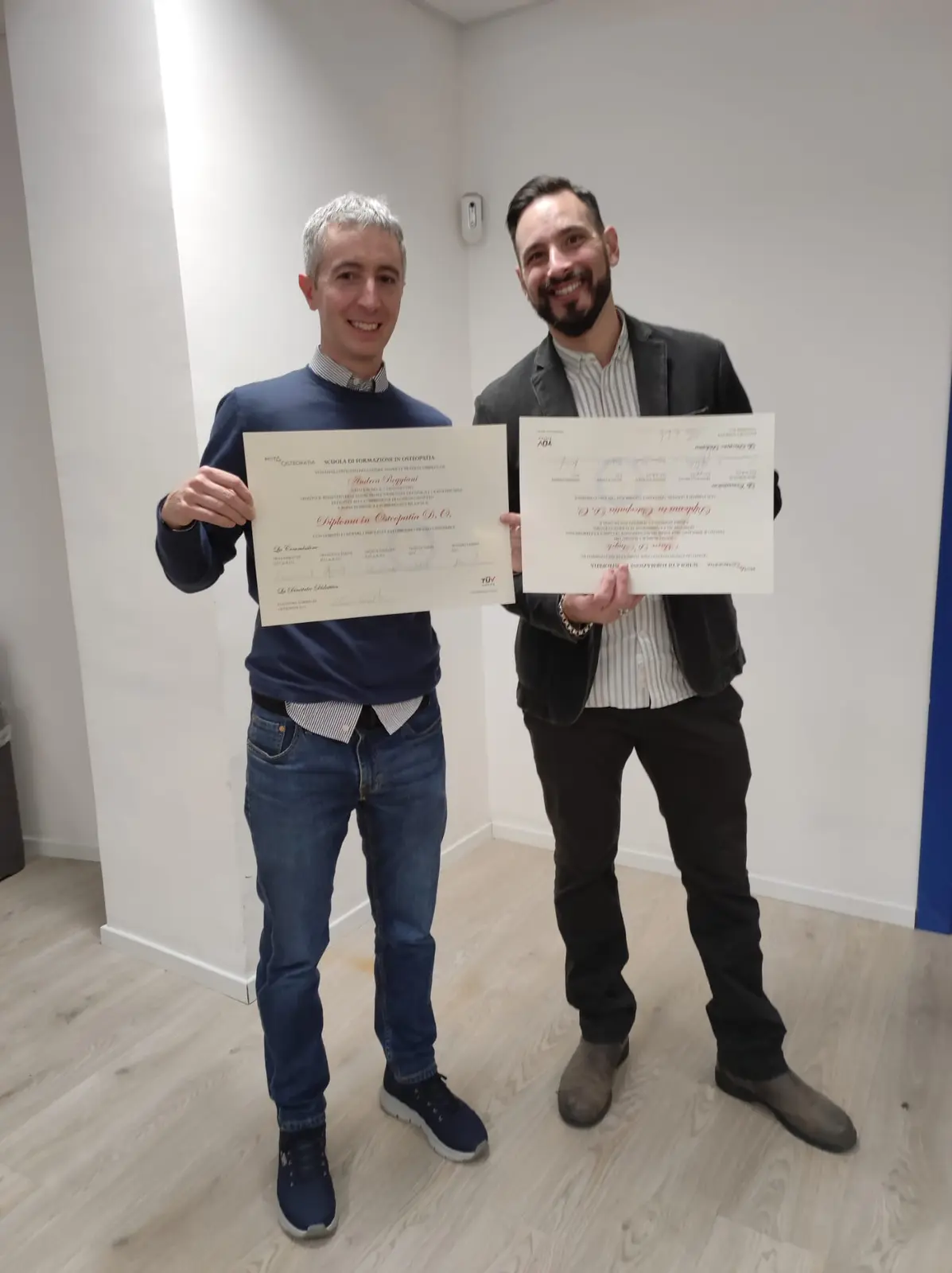 Andrea Reggiani e il collega Marco con i diplomi in Osteopatia